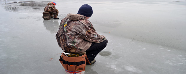 Two ice anglers ice fishing on a lake
