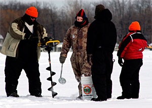 Ice anglers using some of the tools to open holes through the ice - a power auger and simple scoop