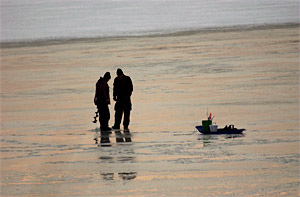 Ice fishing anglers with an ice sled to carry their fishing gear