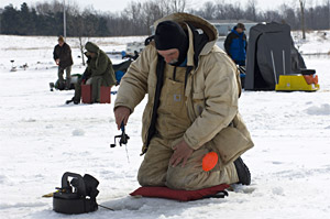 Anglers ice fishing in the open with ice fishing rod and reel