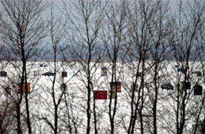 Ice fishing shanties and shacks on thick winter ice