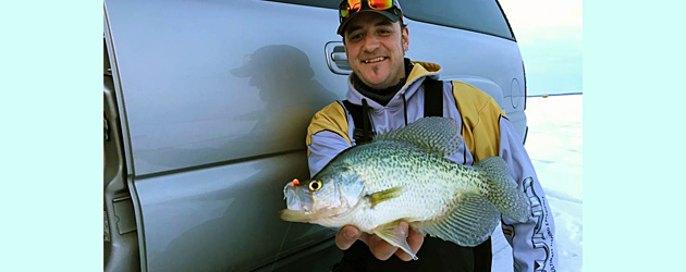 Ray Tiffany shows off a big late ice crappie caught jigging early